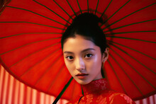 Asian woman in a red dress holding a red umbrella Created With Generative AI Technology