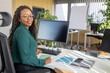 © ADDICTIVE STOCK - Happy businesswoman sitting at computer desk in office