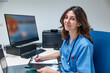© ADDICTIVE STOCK - Young woman doctor sitting at table with laptop smartphone and making note on clipboard