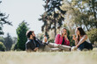 © qunica.com - Carefree friends enjoy a sunny day in the park, laughing, talking, and eating ice cream.