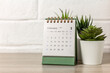 © Елена Николаева - Desk calendar for February 2024 and on the table with copy space.