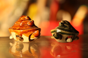 A pair or Two Vastu Shastra and Feng Shui triple turtle or tortoise with selective focus on a glass surfaace, brown and green colour, facing each other