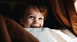 Happy Toddler Boy Smiling in Bed with Morning Sunlight Shining on Face