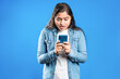 © Dharma - Shocked Indian women looking at mobile phone
