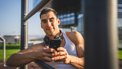 Poster - man young male use mobile phone at outdoor open training park gym