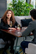 © Guys Who Shoot - portrait of young upset curly woman quarreling on business meeting with colleague or on date with man with glasses of champagne