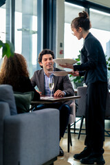 Wall Mural - a girl waiter serves orders to guests the concept of hospitality and service in a high-class restaurant