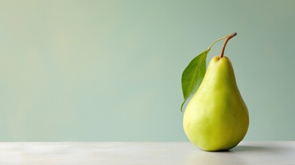 Wall Mural -  a pear with a green leaf sticking out of it's side sitting on a table with a green wall in the background.