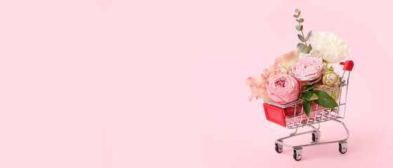 Wall Mural - Small shopping cart with beautiful flowers on pink background with space for text