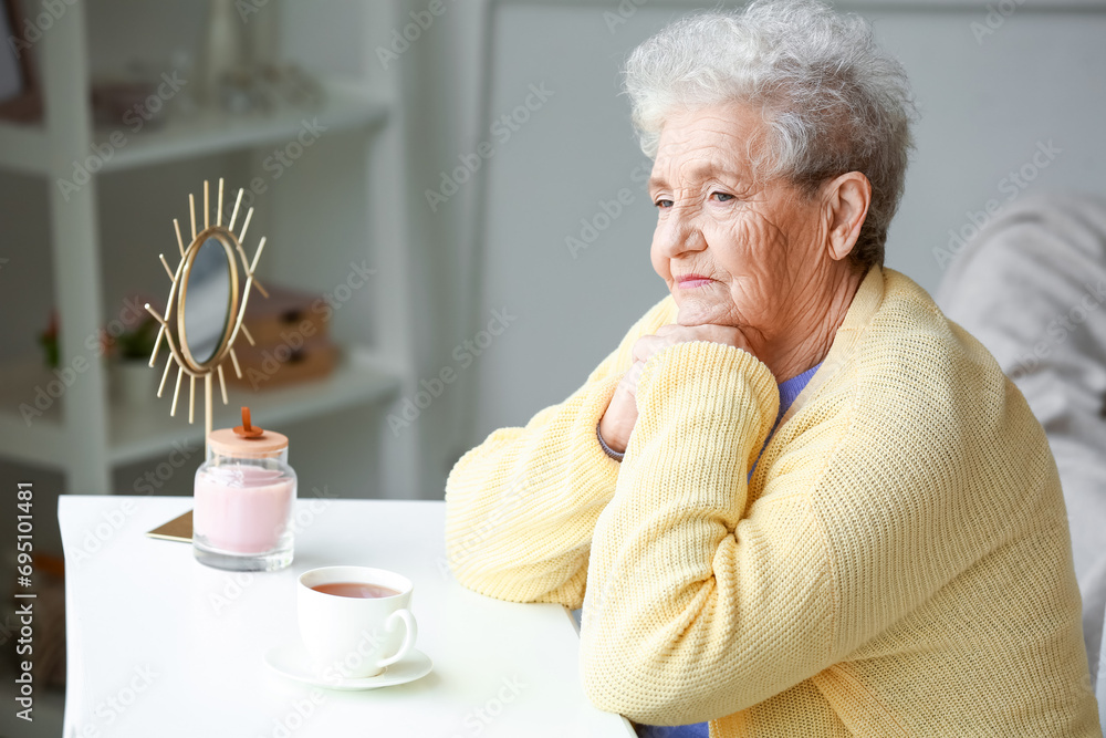 Thoughtful senior woman sitting at home