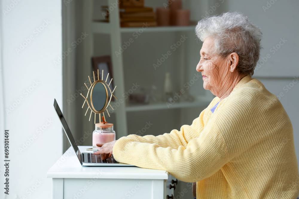 Senior woman using laptop at home