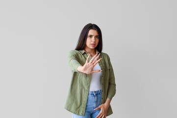 Wall Mural - Young woman having panic attack on light background