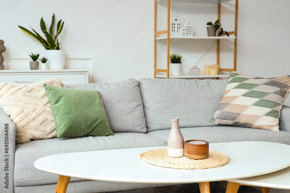 Vase with candle on coffee table in light living room
