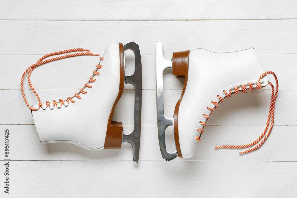 Ice skates on white wooden background