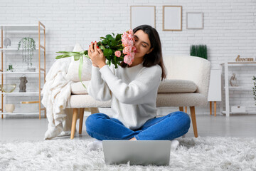 Wall Mural - Young woman with roses and laptop video chatting on online date at home