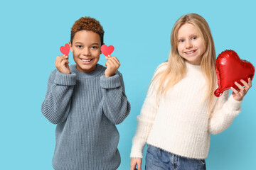 Cute little children with red paper hearts and air balloon on blue background. Valentine's day celebration