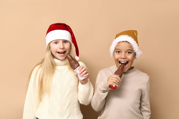 Canvas Print - Cute little children eating chocolate Santa Claus on brown background