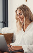 © Daniel - Portrait of one young attractive blonde woman using laptop pc computer on couch relaxing surfing the net at home. Working online concept lifestyle.