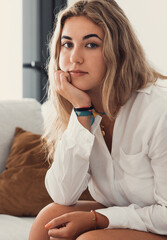 Wall Mural - Positive serious millennial model girl home female head shot portrait. Beautiful young adult Caucasian woman looking at camera, posing in apartment. Front profile picture.