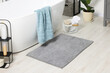 Soft light grey mat near tub in bathroom