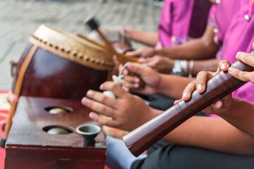 Boys playing Thai musical instrument close up on oboe. 