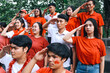 © Gatot - Football fans with red and white t-shirts giving salute gesture before watching soccer match event.