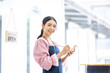 © David - Portrait of happy waitress standing at restaurant entrance. SME entrepreneur young business asian woman attend new customers near door. Smiling small business owner showing open sign in her shop.
