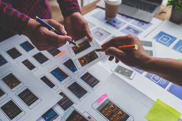 ux developers and ui designers brainstorm on tabletop mobile app layout design planning design color
