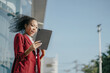 © NINENII - Happy African woman having fun doing video call using smartphone during free time. Office worker at business center.