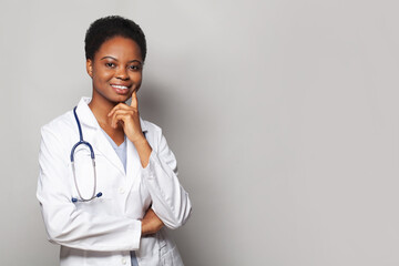 Wall Mural - Happy physician woman medical worker with stethoscope standing on white background