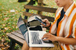 © DragonImages - Software developer checking notifications on smartphone and coding on laptop