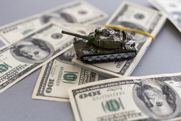 Wall Mural - toy tank on the background of dollar bills