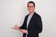 © KrishnaTedjo - Asian businessman smiling confident while writing a list