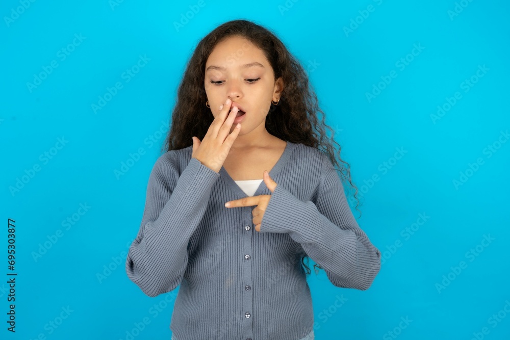 Finger Getting Zapped Shocked Beautiful teenager girl look surprisedly down, indicates at ...