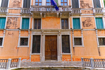 Old town of Venice with historic house with eu flag on a blue cloudy summer day. Photo taken August 6th, 2023, Venice, Italy.