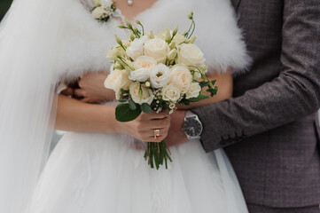 Wall Mural - A beautiful wedding bouquet in the hands of the bride. Bouquet with white flowers in the hands of the bride