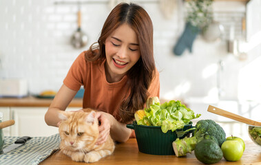 Portrait of enjoy happy asian woman smiling playful love with happy pet kitten,cute brown cat,animals and lifestyle,cat food product,funny ginger cat lying at home.