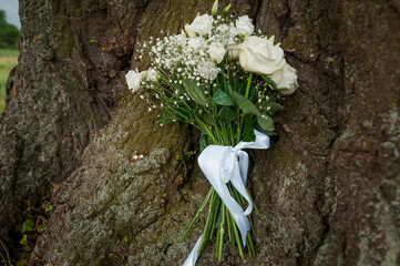 Wall Mural - Beautiful wedding bouquet on a wood background. Bride's bouquet with white roses on a brown background