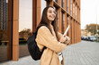 © ADDICTIVE STOCK - Smiling student with backpack outside college building