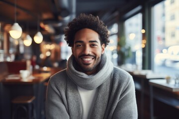 Wall Mural - Portrait of a cheerful afro-american man in his 30s wearing a cozy sweater against a bustling city cafe. AI Generation