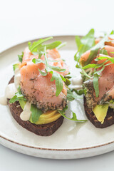 Wall Mural - Rye toast with smoked salmon, avocado, hollandaise sauce and arugula.