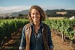 © Markus Schröder - Portrait of a joyful woman in her 40s wearing a rugged jean vest against a backdrop of rolling vineyards. AI Generation