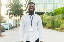 Smiling Black Businessman Walking With Laptop