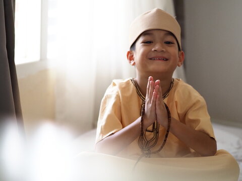 Asian muslim kid prays.Portrait of happy Asian muslim 6 years old boy.