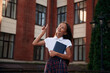 © standret - Thinking, thoughtful look. School girl in uniform is outdoors near the building