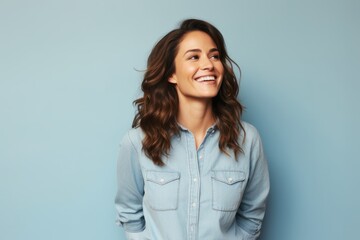 Poster - Portrait of a smiling woman in her 30s sporting a versatile denim shirt against a pastel or soft colors background. AI Generation