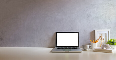 Wall Mural - Laptop computer with empty screen, stationery and potted plant on white table in bright office.