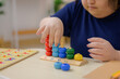 © เลิศลักษณ์ ทิพชัย - A close-up of a girl developing her skills. Playing a sorting and counting game at the living room table at home