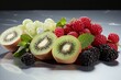 ripe fruits on a light surface: kiwi, raspberries, blackberries.