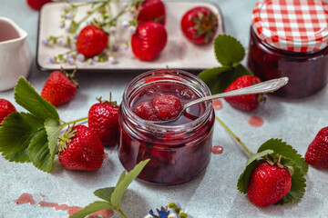 Wall Mural - Fresh homemade strawberry jam in glass jar on a light background.